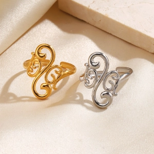 Golden and silver stainless steel open rings with hollow geometric patterns on silk background