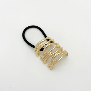 Close-up of a hollow wavy golden alloy hair tie with black elastic band detail