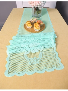 Detail of mint green lace table runner featuring rose floral embroidery and scalloped edges