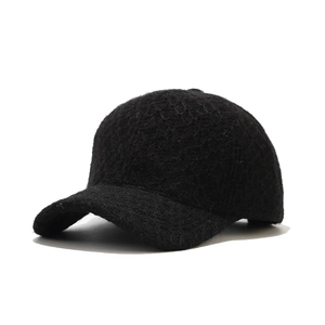 Close-up of the thick wool knit texture and reinforced stitching on a black winter baseball cap