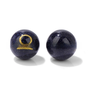Macro shot of 10mm blue sand stone beads with golden zodiac signs for DIY jewelry making
