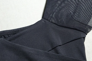 Detail shot of black ruched dress featuring mesh stitching and premium sewing texture