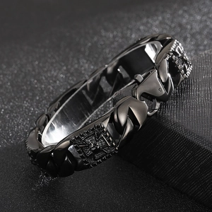 Macro detail of gothic pharaoh skull relief on black stainless steel Cuban chain bracelet