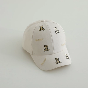 Détail d'une casquette en sergé beige avec broderie ours marron et texte bear brodé
