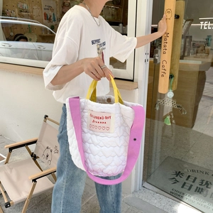 Détail du sac cabas blanc matelassé à cœurs avec anses jaunes et bandoulière rose