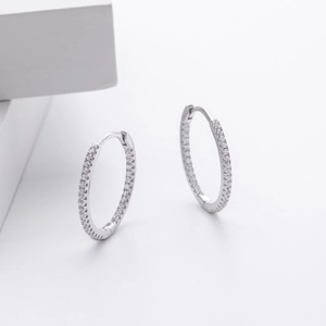 Gros plan de boucles d'oreilles créoles en argent 925 avec zircons sur fond blanc