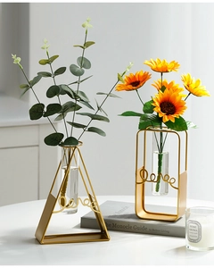 Detail of minimalist gold geometric metal frame glass vase with Love script design