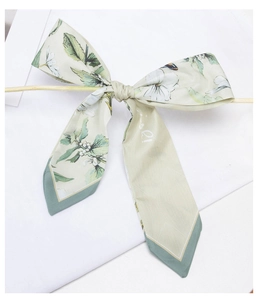 Close-up of floral print satin hair scarf tied in a bow with elegant wood stick detail