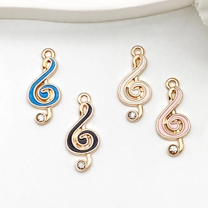 Detailed macro view of colorful enamel musical note charms with sparkling rhinestones