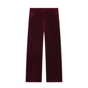 Detail of burgundy velvet straight-leg trousers with soft texture and rich sheen