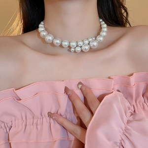 Oversized white pearl choker necklace with silver spacers on a fashion model