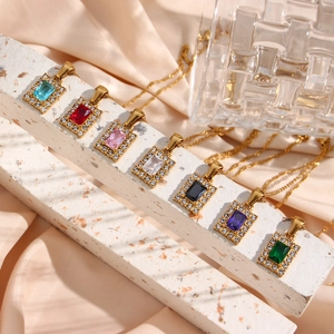 Golden water wave necklaces with colorful rectangular zircon pendants on marble stand