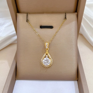 Detailed close-up of a pear-shaped gold-plated necklace pendant with zircon pavé setting