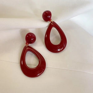 Vintage red resin hollow teardrop earrings with silver needles on white silk