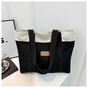 Detail of minimalist canvas tote with contrast panels and FASHION leather tag