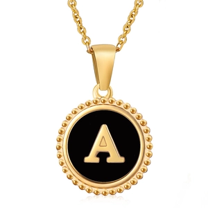 Macro shot of gold-plated titanium steel necklace with black round letter A pendant