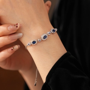 Close-up of vintage silver bracelet with blue oval gemstone and pavé crystal accents