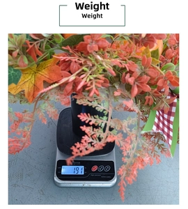 Detail view of fall harvest wreath with maple leaves and bow being weighed on a scale