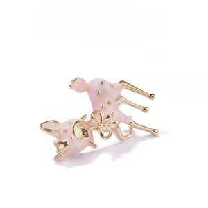 Detailed close-up of a pink deer brooch with a golden bow and enamel finish