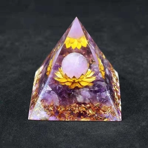 Macro detail of orgone pyramid with amethyst crystals and gold lotus flower core
