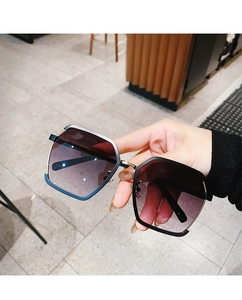 Close-up of geometric semi-rimless sunglasses with gradient lenses in a hand-held view