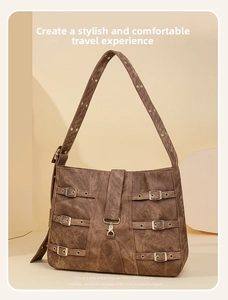 Close-up of vintage brown tote bag featuring metallic buckle straps and suede texture