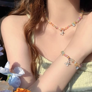 Colorful beaded butterfly necklace and bracelet set with pastel heart stones on a model