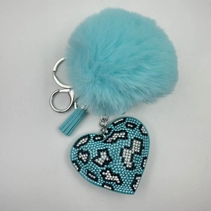 Detailed view of light blue plush ball keychain with leopard heart rhinestone and tassel