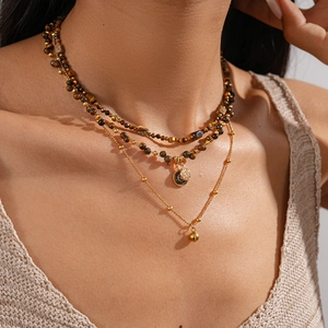 Detail of multi-layered 18k gold plated tiger eye beaded necklace with star moon pendant