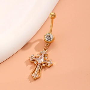 Macro detail of golden cross navel ring with sparkling zircon stones and a polished finish