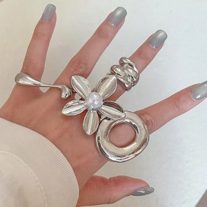 Detailed view of silver flower ring set with pearls and textured metallic bands