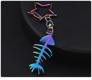Detail of rainbow-plated fishbone keychain with star clasp on black leather background