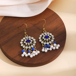 Detail of vintage bohemian earrings with blue gems, white rhinestones and pearl pendants