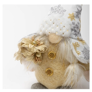 Detail of Christmas gnome plush with snowflake hat and golden flower decoration