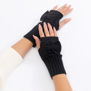 Detailed close-up of black knitted fingerless gloves with a decorative bow on the back