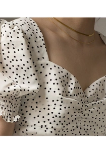 Detail of sweetheart neckline and puff sleeves on white polka dot french retro blouse