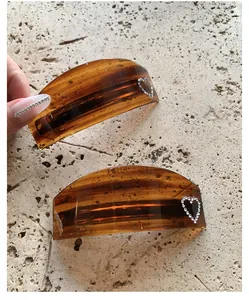Detail of tortoise shell hair clips with heart rhinestone accents on a stone background