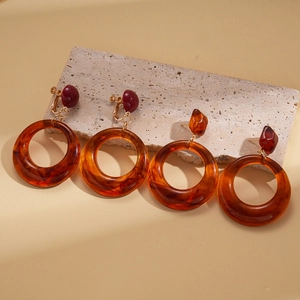 Boucles d'oreilles vintage en résine ambre de forme géométrique sur pierre beige