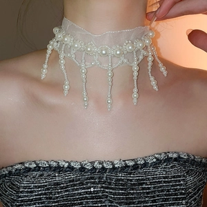 Close-up of elegant mesh lace choker with pearl tassels on model's neck