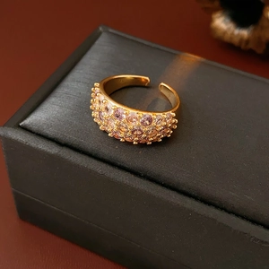 Detailansicht der 18K vergoldeten offenen Rings mit lila und rosa Zirkon-Besatz auf Box
