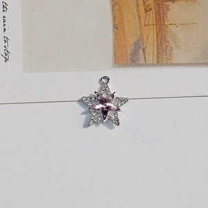 Macro shot of a silver star pendant with purple crystal and pave zircon details