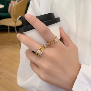 Detail of 18K gold-plated chain rings with sparkling zircon stones on a model's hand