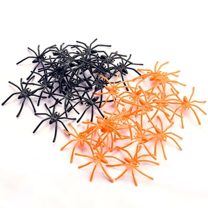 Realistic small plastic spiders in black and orange for Halloween decoration and pranks