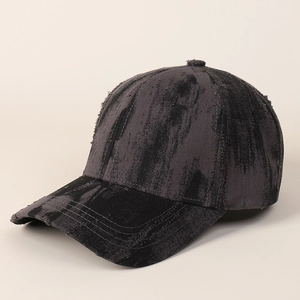 Detail of distressed vintage tie-dye baseball cap with frayed edges and washed texture
