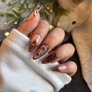 Brown almond press-on nails with 3D floral carving and zebra pattern designs