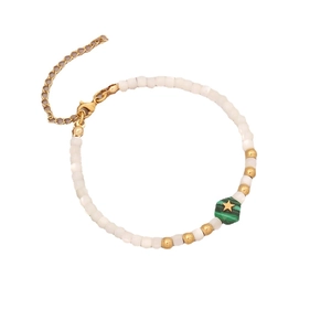 Elegant beaded bracelet with pearls, green star charms, and gold accents on white background