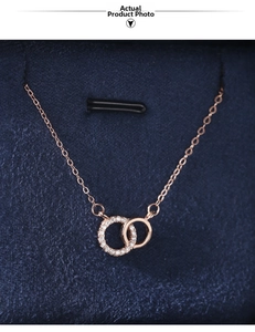 Macro detail of 925 sterling silver interlocking double ring necklace in rose gold finish
