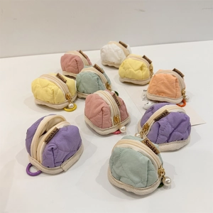 Close-up of colorful quilted mini earphone pouches with pearl charms and clip hooks