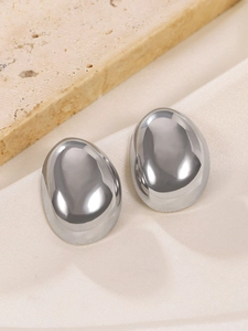 Macro detail of silver stainless steel drop earrings with a polished mirror finish