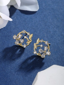 Detailed close-up of a floral wreath earring with gold plating and sparkling zircon stones